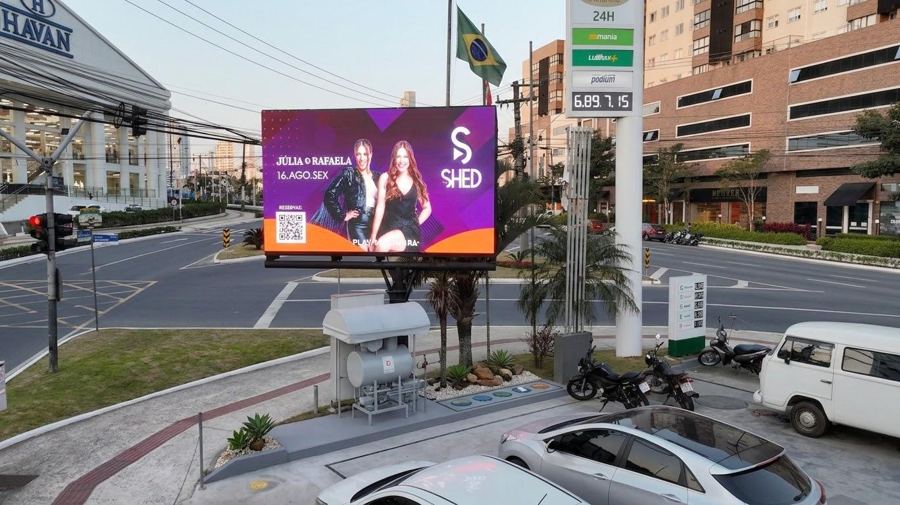 Painel de LED instalado em posto de combustíveis, exibindo campanha publicitária